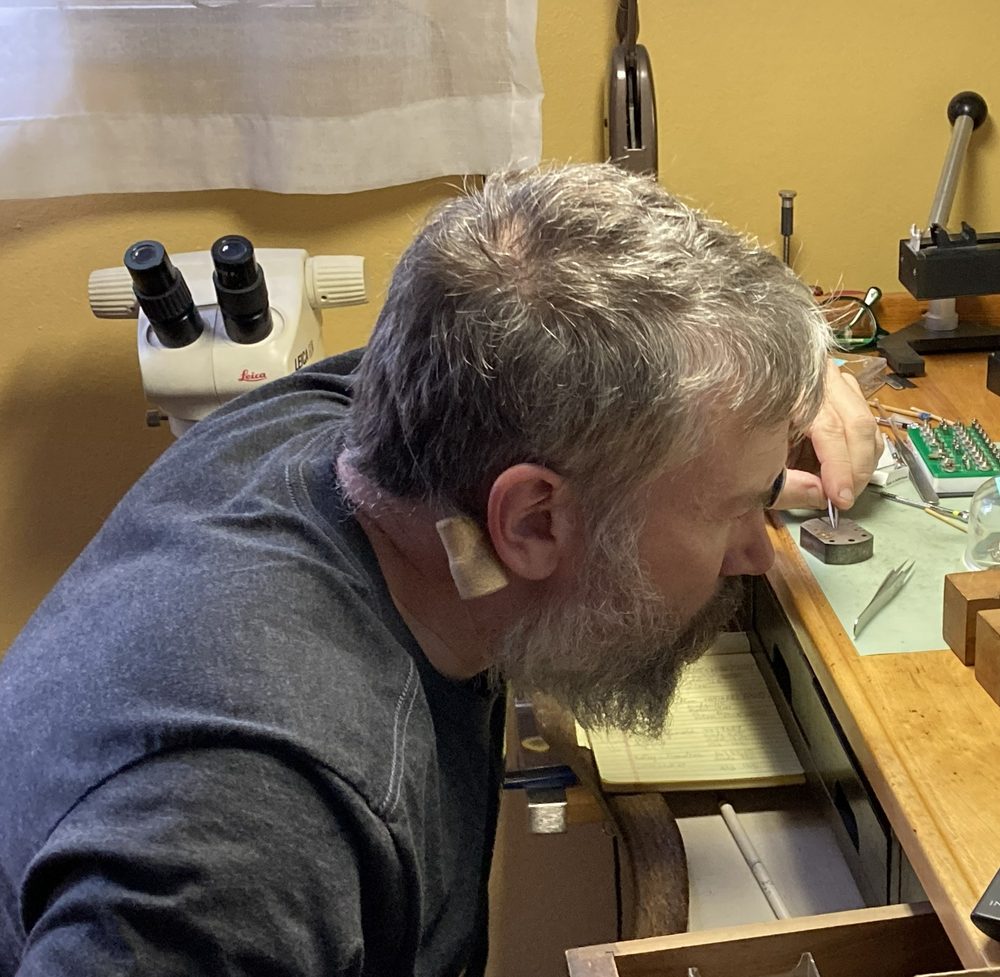 Ryan Bramlett working at his bench beside a microscope
